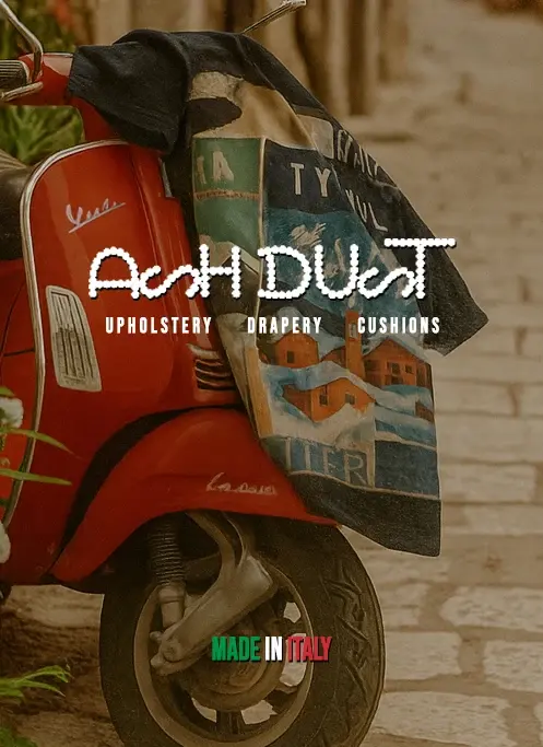 Vespa rossa con una maglietta Ash Dust appesa al manubrio, su una strada di pietra